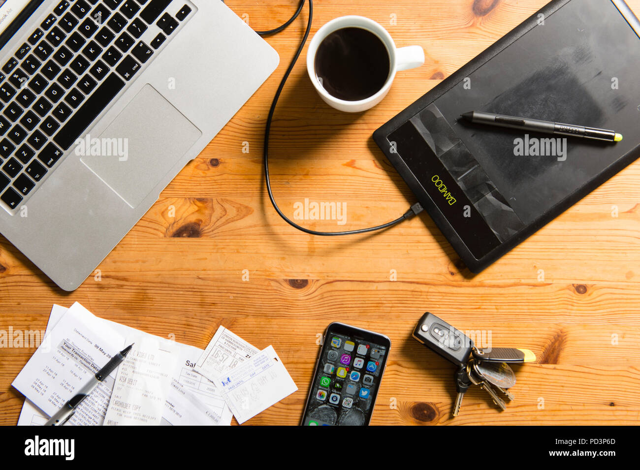 Top down view of macbook with coffee, receipts, keys, wacom tablet and  iphone Stock Photo - Alamy