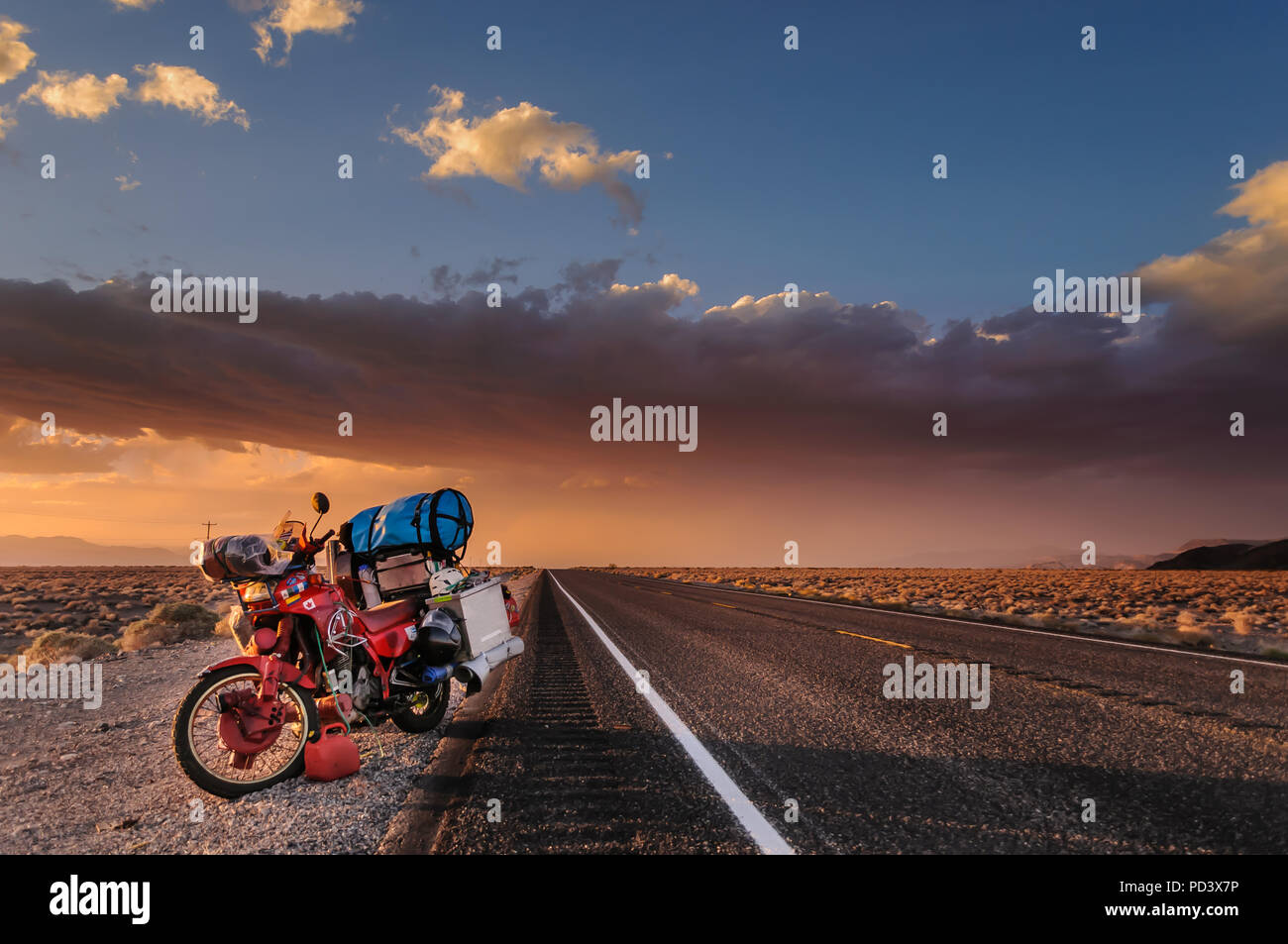 Motorcycle on roadside, getting away from a huge windstorm between Nevada and California, Bishop, California, United States Stock Photo