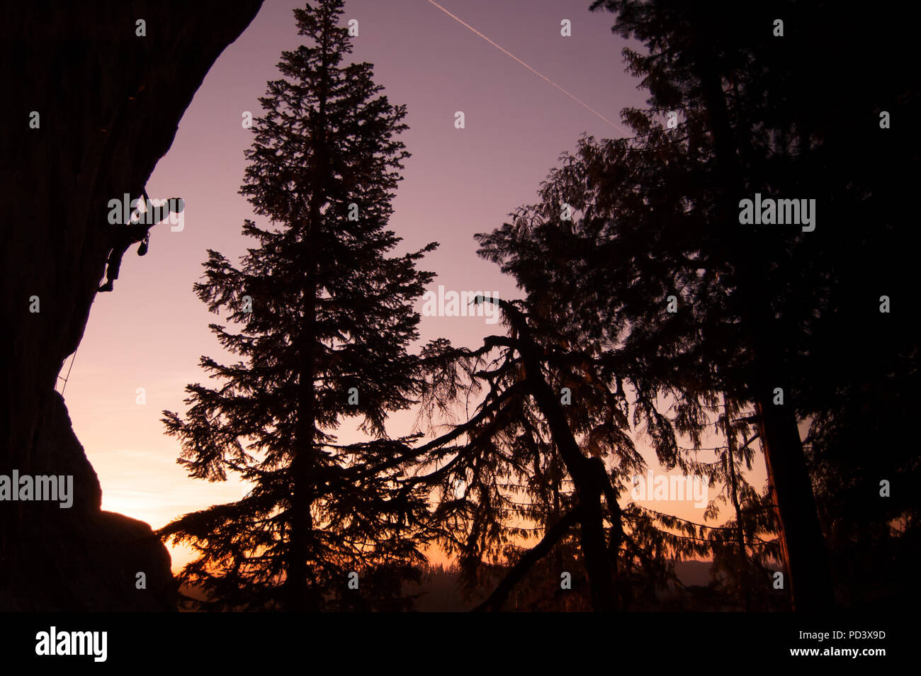 Silhouette of rock climber rock climbing at sunset, Flagstone, Eugene