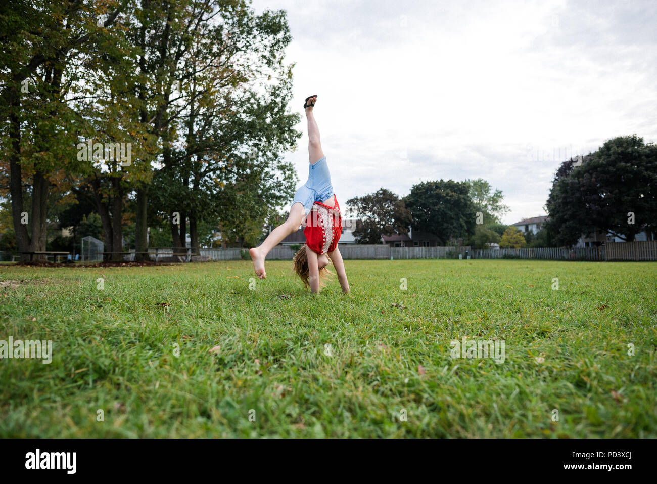Girl doing cartwheel in park Stock Photo