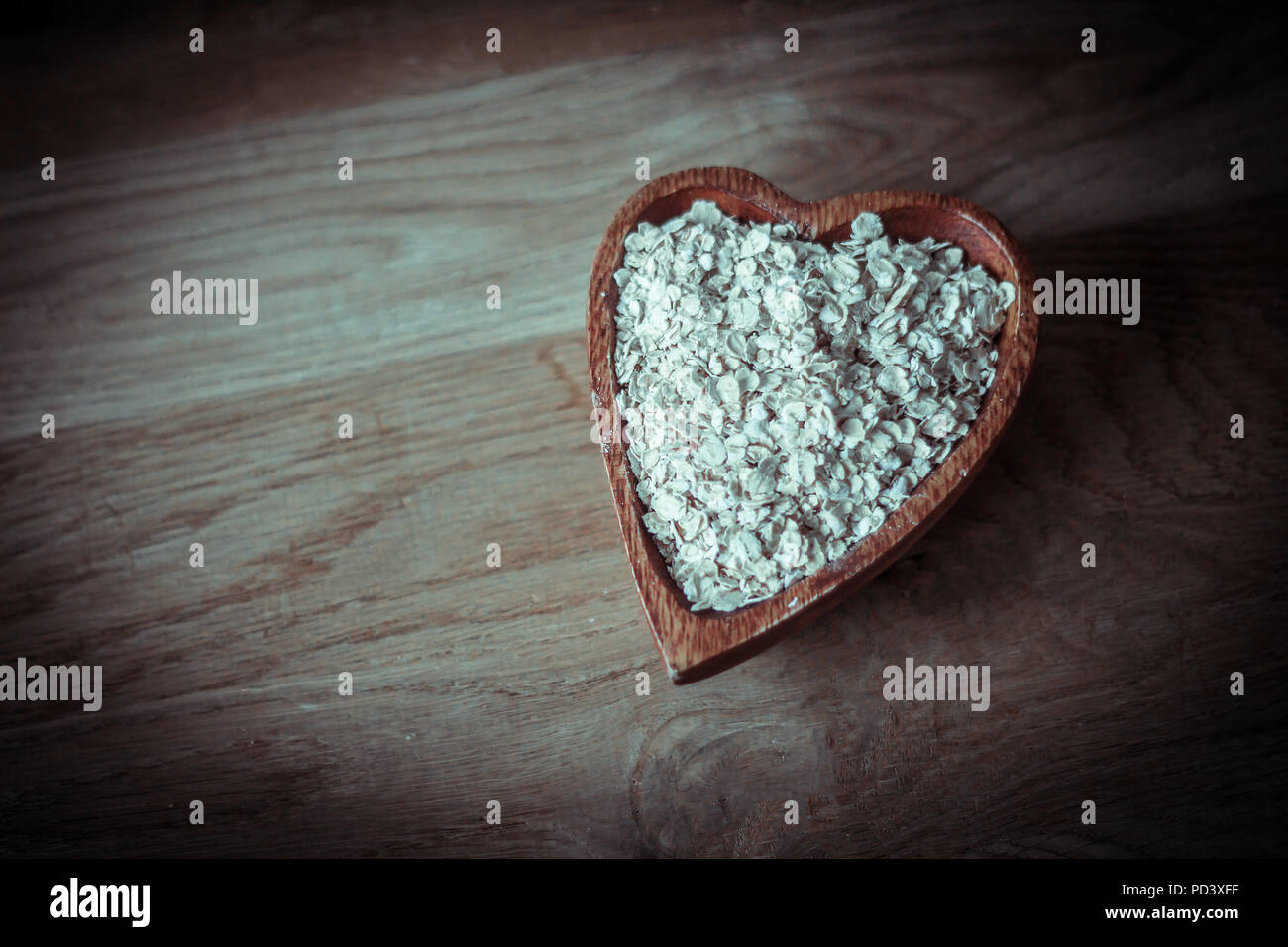 useful oat flakes in a wooden bowl Stock Photo