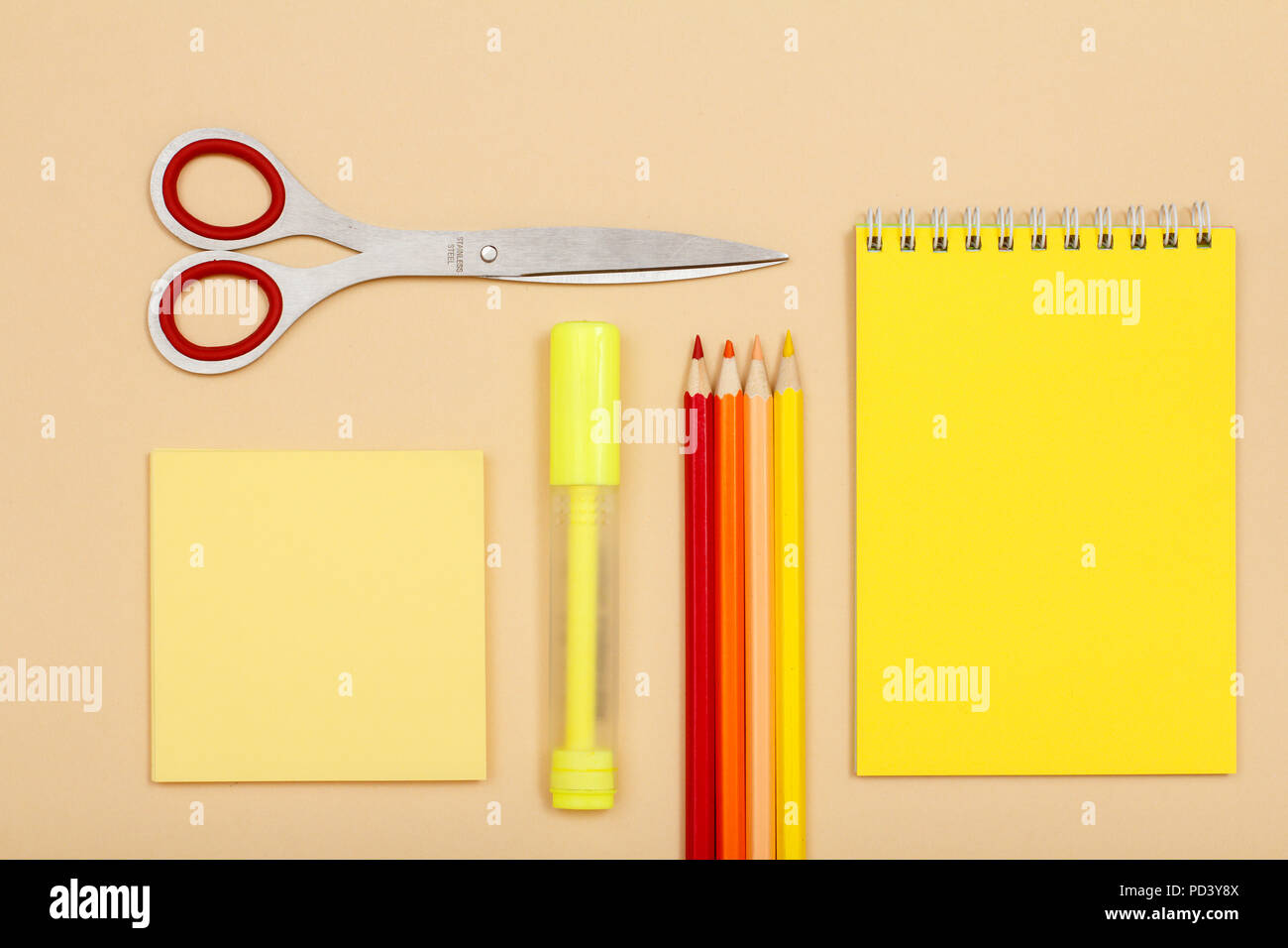 Writing utensils (notebook, pens, pencils, paper clips, paper, pencil  sharpener, buttons) on a wooden table. Frame from school utensils. Stock  Photo