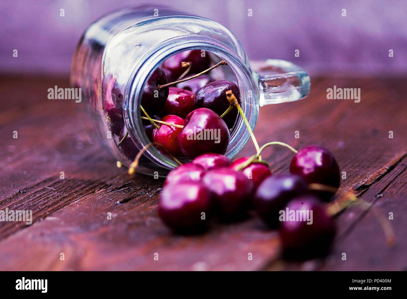 Fresh Cherries falling out of a glass jar Stock Photo Alamy