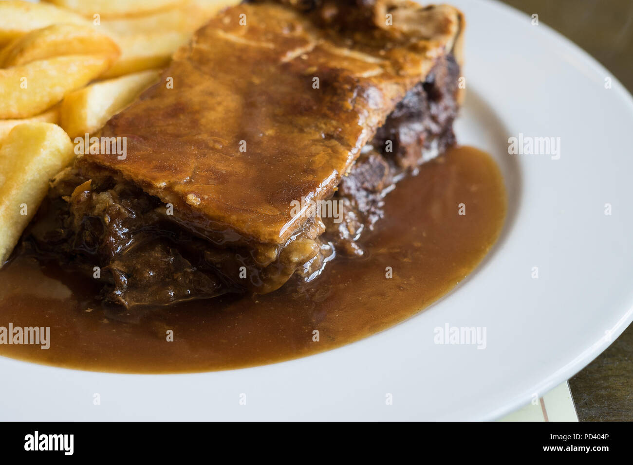 Meat pie with shortcrust pastry, chips and vegetables Stock Photo