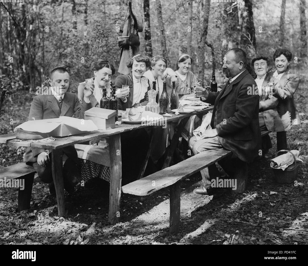 Family toasts during a picnic outside, ca. 1915. Stock Photo