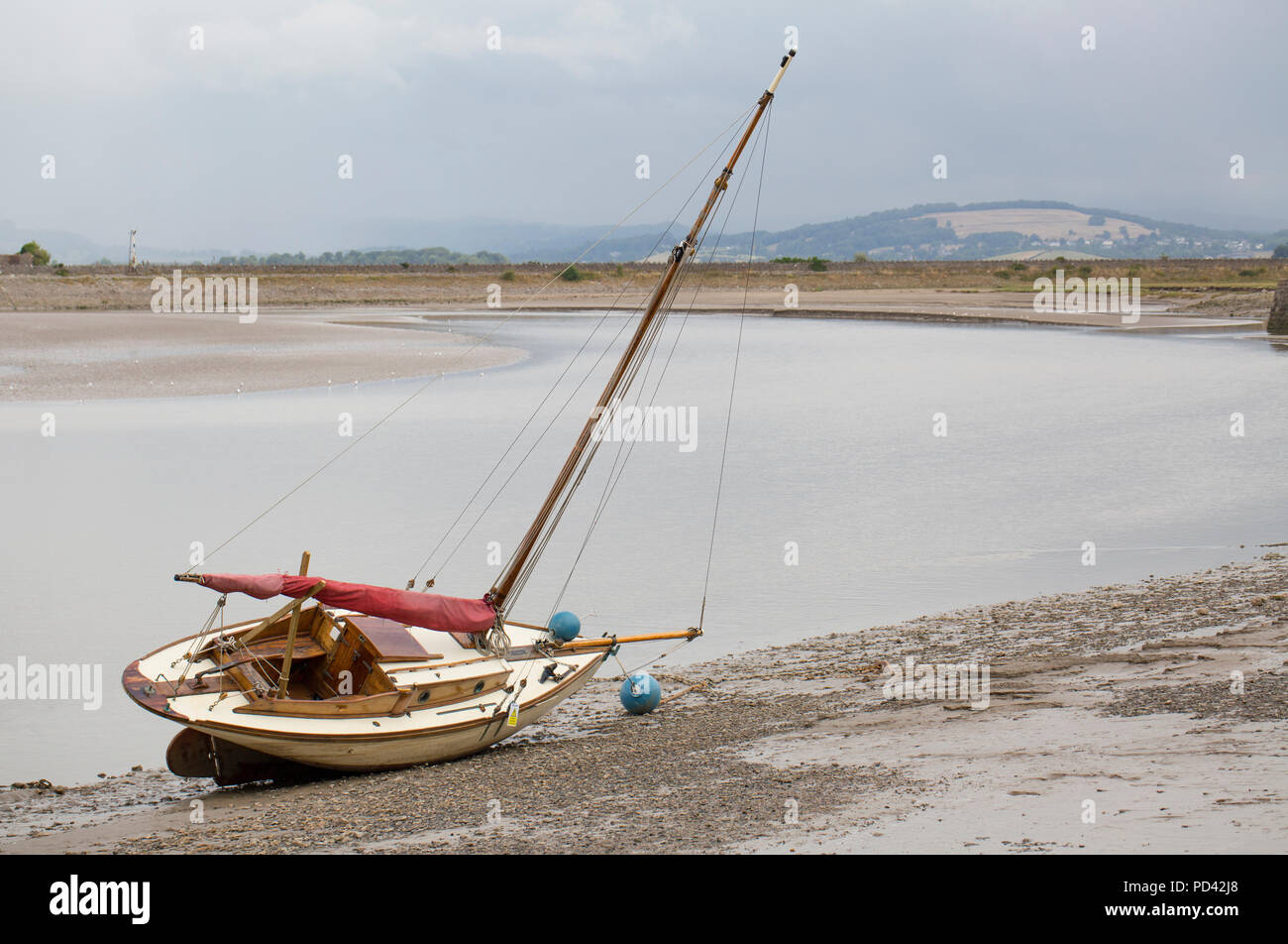 A yacht at low tide on the edge of the Kent estuary next to the village of Arnside in Cumbria North West England UK GB Stock Photo