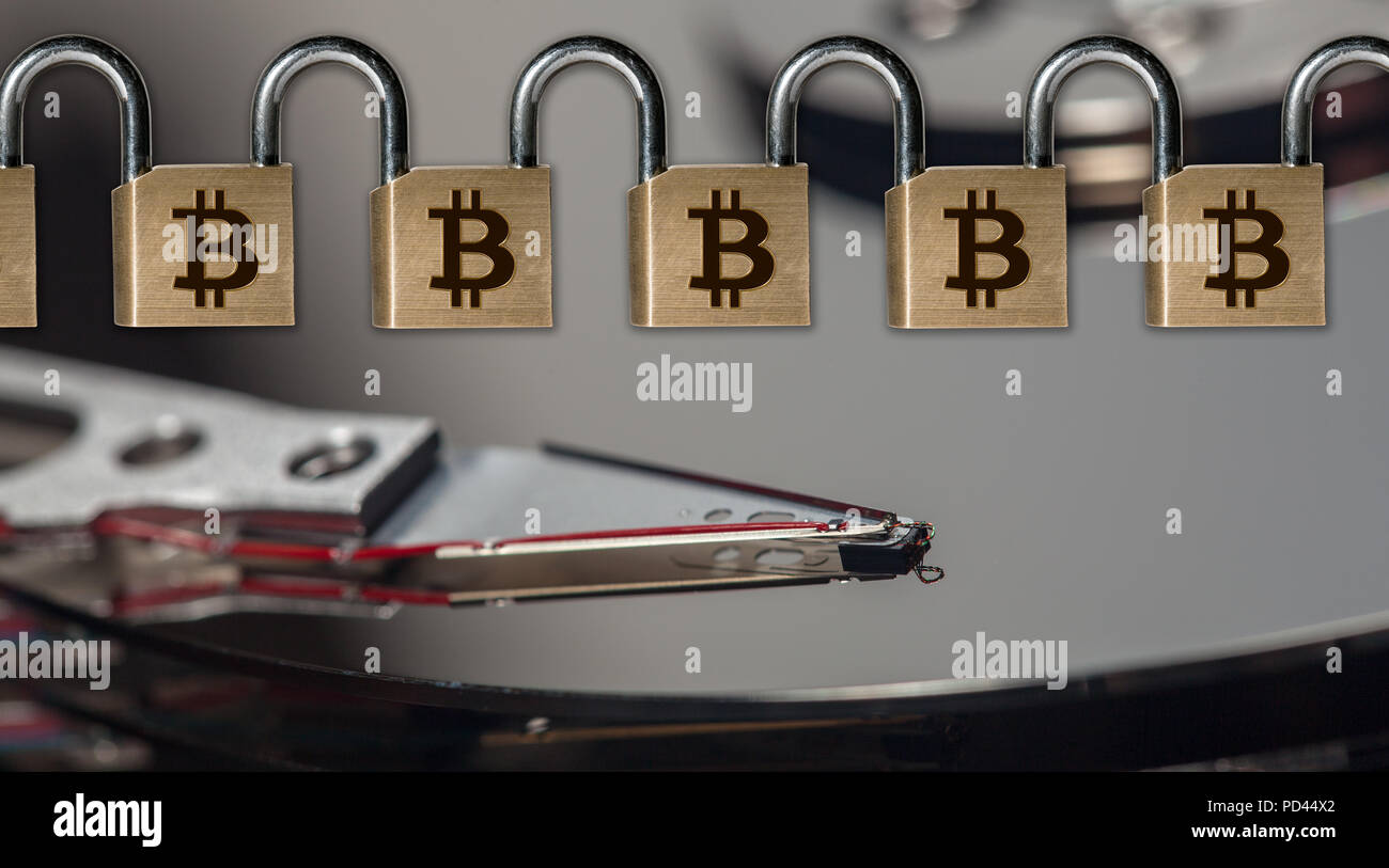 Chain of brass padlocks to illustrate blockchain above computer hard ...