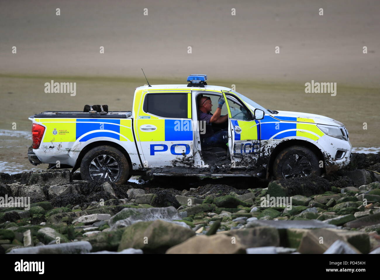 A Port of Liverpool Police vehicle is extracted after it became stuck in  the mud on Crosby beach in Merseyside during a search for a missing woman.  Officers had been forced to