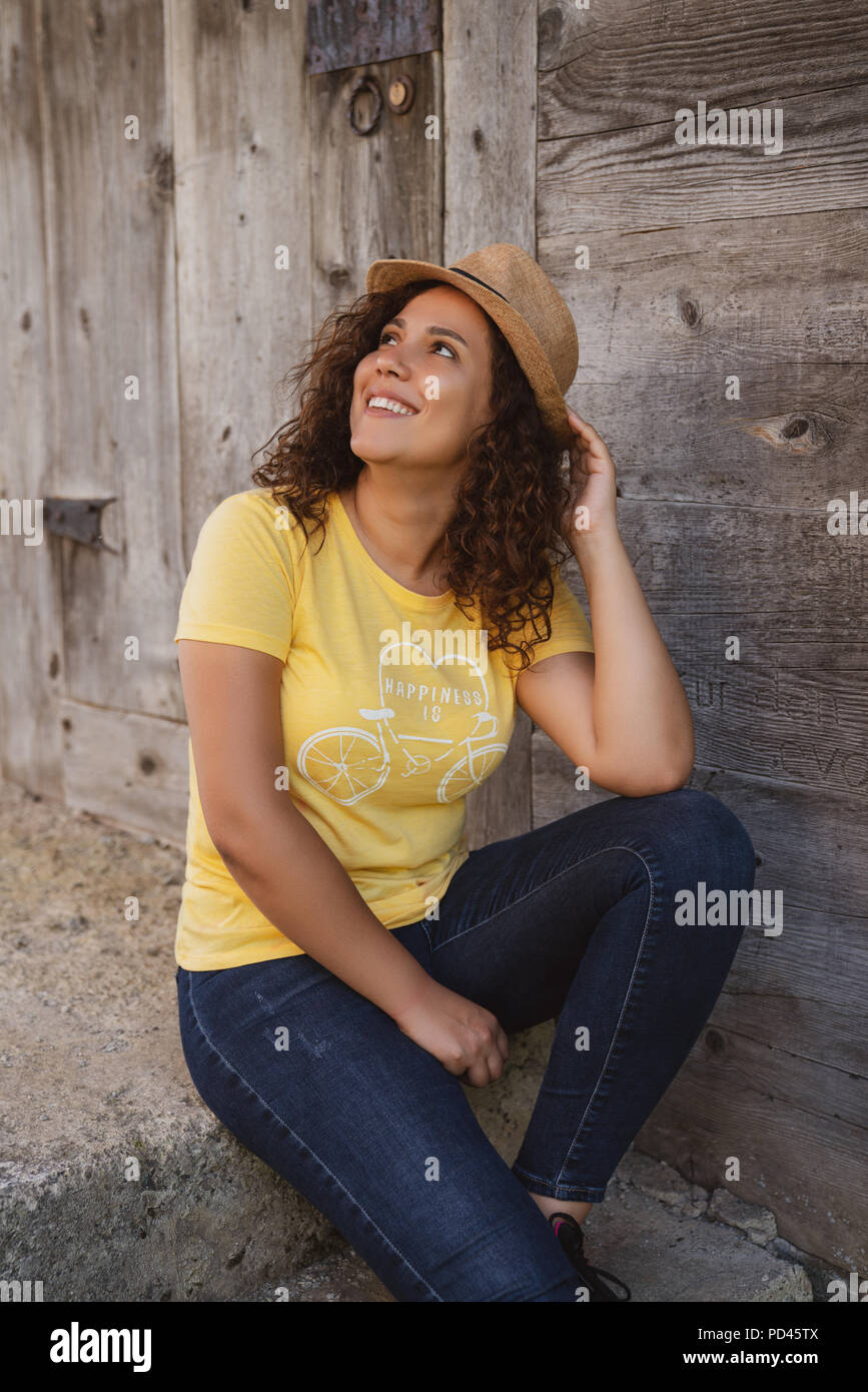 Close up portrait of a cheerful curly young woman smiling outdoors. Stock Photo