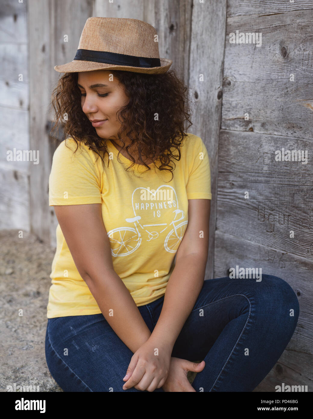 Close up portrait of a curly young woman sitting outdoors. Stock Photo
