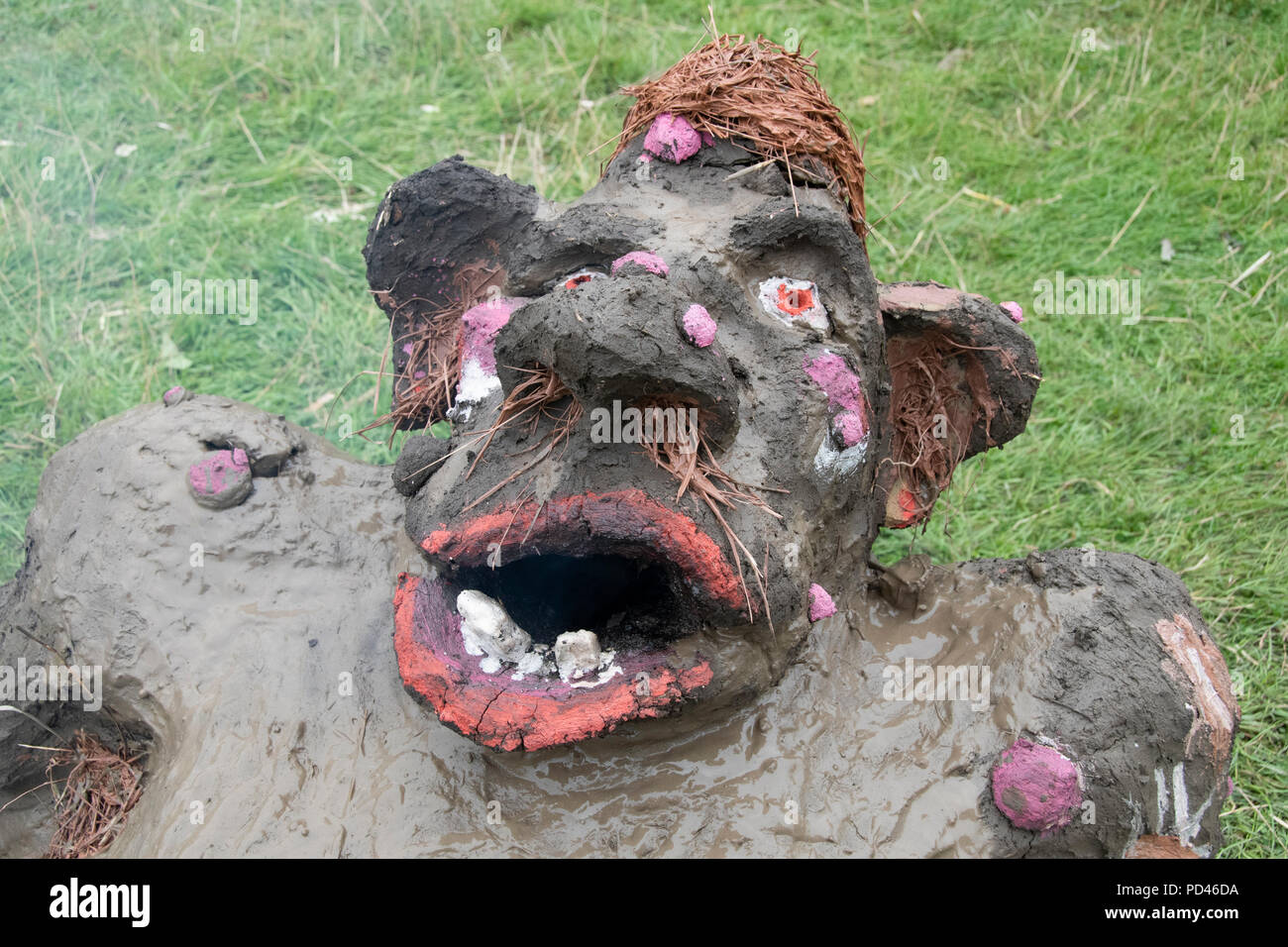 Chepstow, Wales – Aug 14: Make-up decorates the face of a newly made troll faced wood fired earth oven on 14 Aug 2015 at The Green Gathering Stock Photo