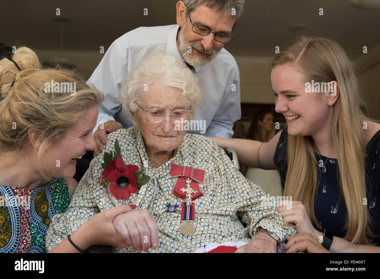 Britain's longest-serving poppy seller, 103-year-old Rosemary Powell, with grand daughters Emma Powell (left) and Rachel Powell and son Anthony, after she was presented with an MBE at her retirement home in west London by Vice Lord-Lieutenant of Greater London, Colonel Jane Davis. Stock Photo