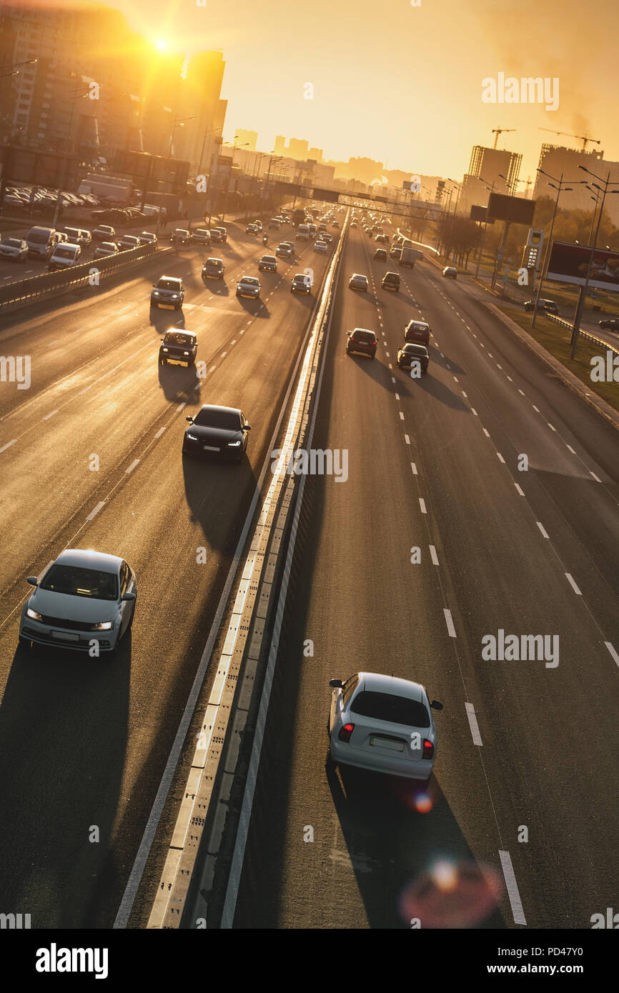 Cars on highway. Sunset cityscape. Contrejour wallpaper Stock Photo