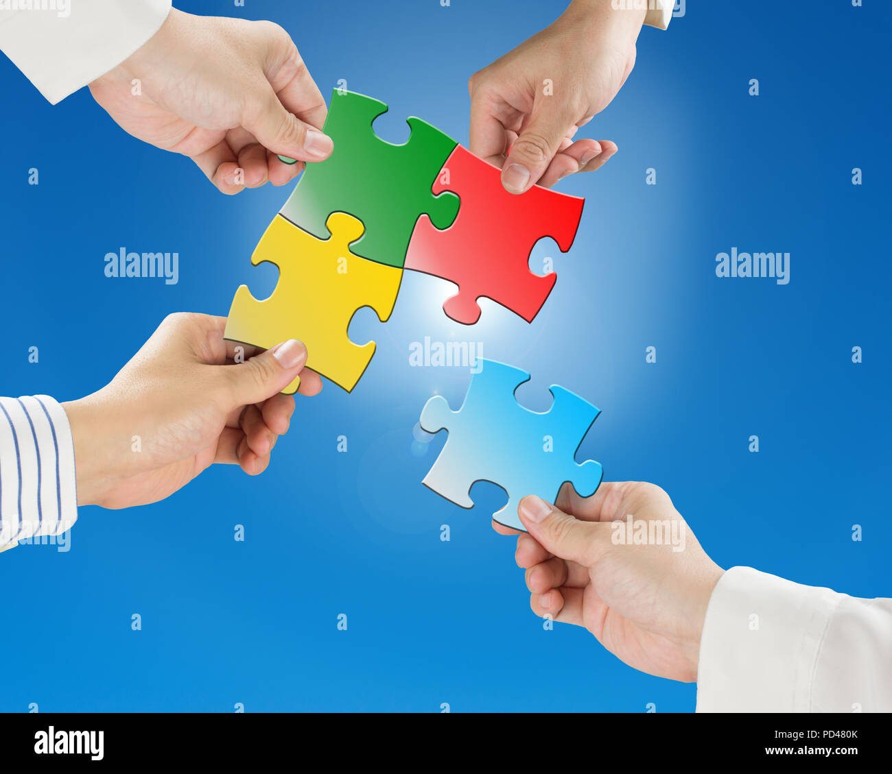 Team work concept, Hands hold puzzles with clear blue sky and sun light