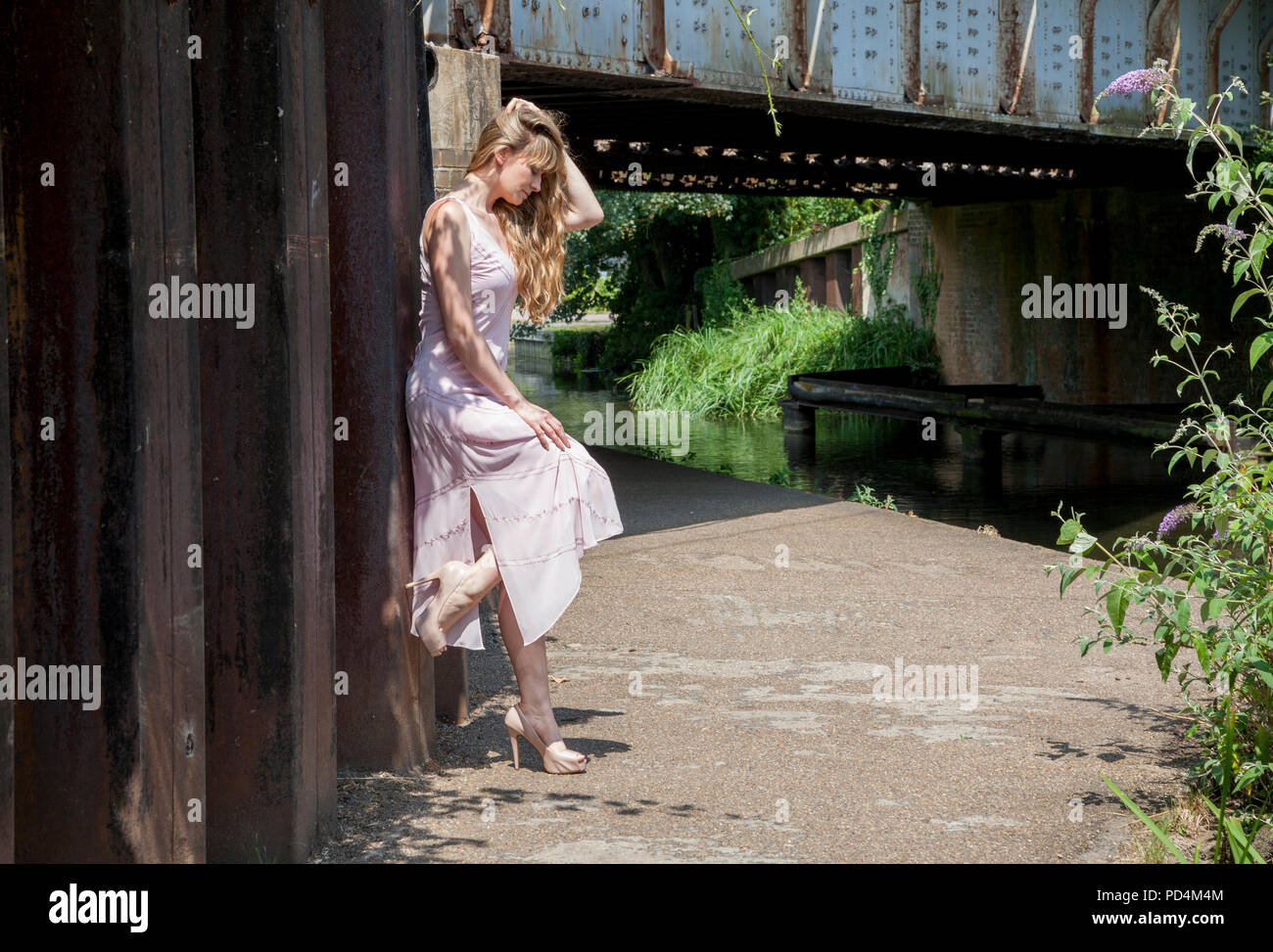 Lady leaning against railway bridge Stock Photo