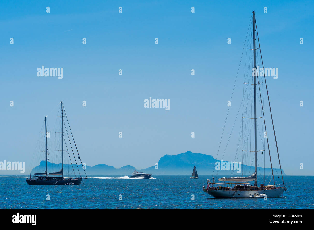 The island Capri seen behind boats from the waterfront in Naples, Italy Stock Photo