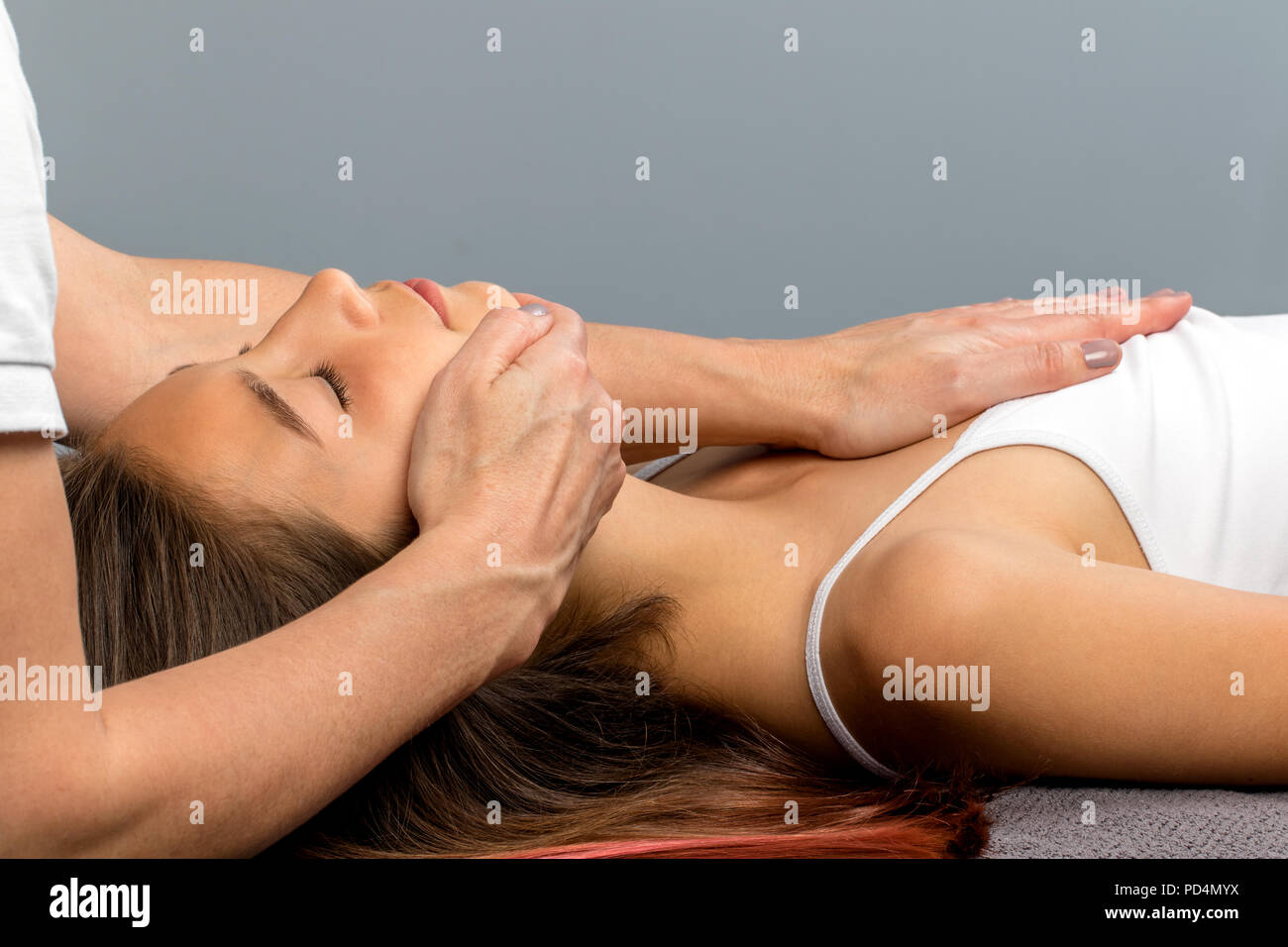 Close up of little girl at osteopathic therapy session. Therapist manipulating neck and chest on child. Stock Photo