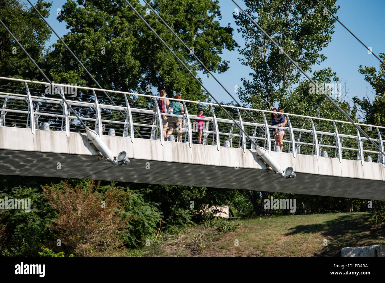 People walking across a footbridge on a summer day in Wichita, Kansas, USA. Stock Photo