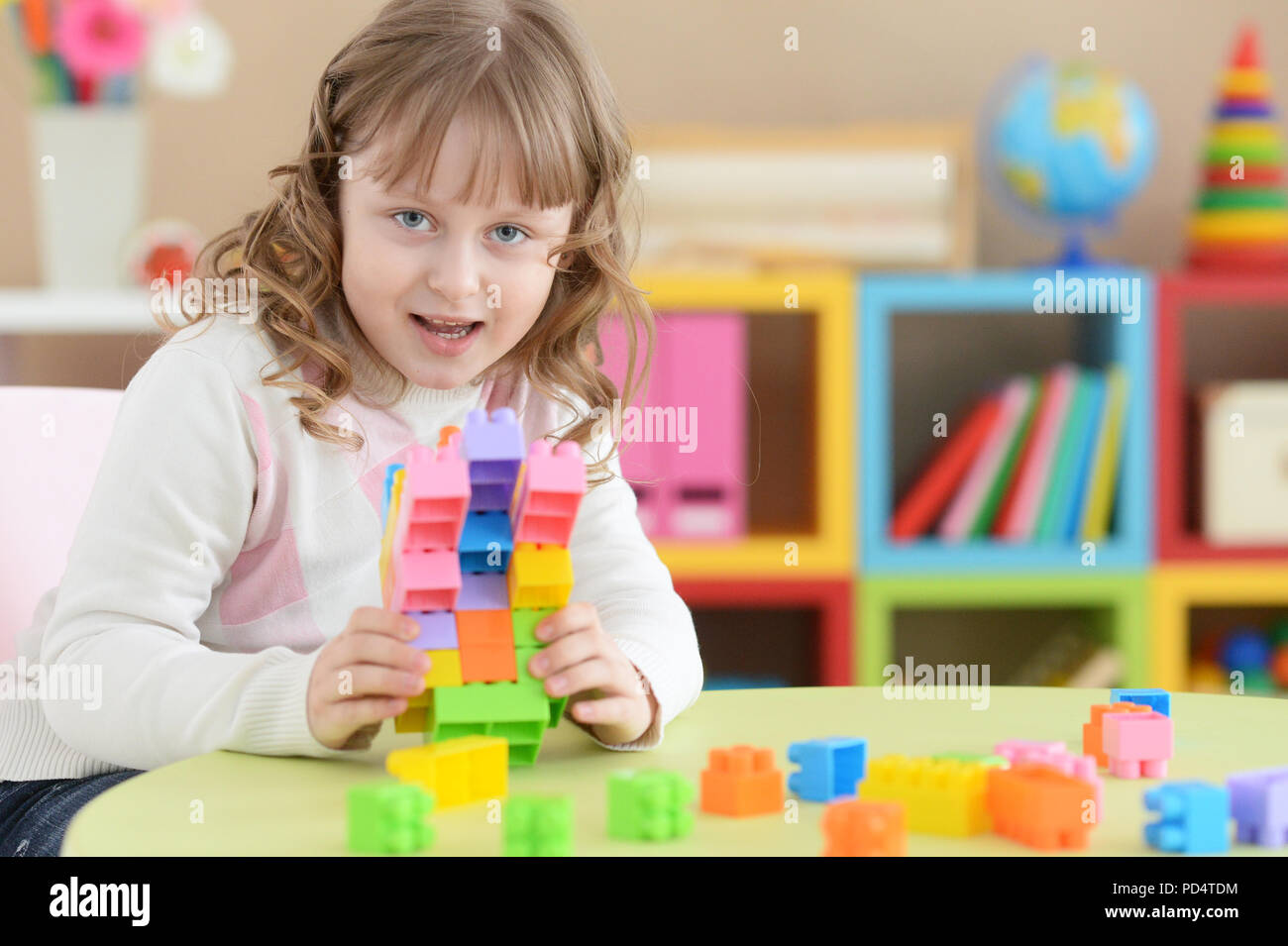 little girl playing with colorful plastic blocks Stock Photo - Alamy