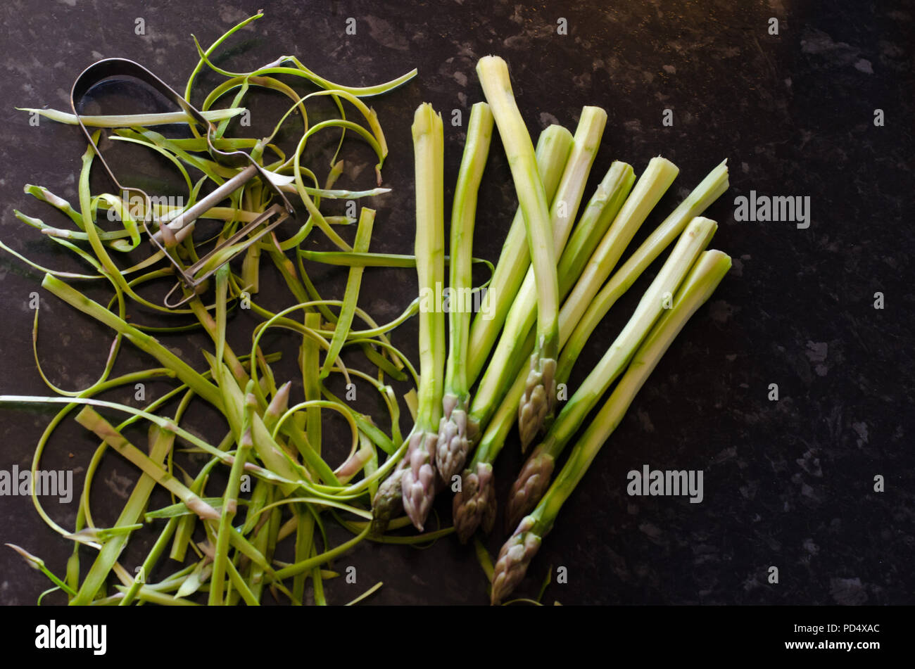 Peeled green asparagus on a dark background. Stock Photo
