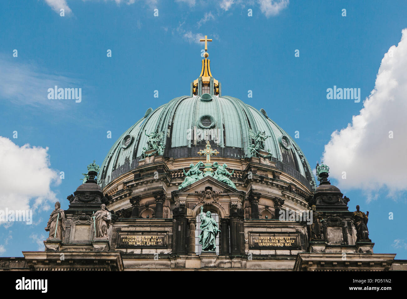 The Berlin Cathedral is called Berliner Dom against the blue sky. Beautiful old building in the style of neoclassicism and baroque with cross and sculptures. Berlin, Germany Stock Photo