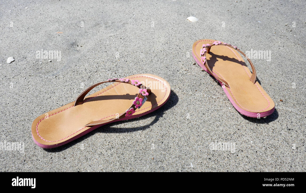 Close up of a pair of sandals on a beach Stock Photo