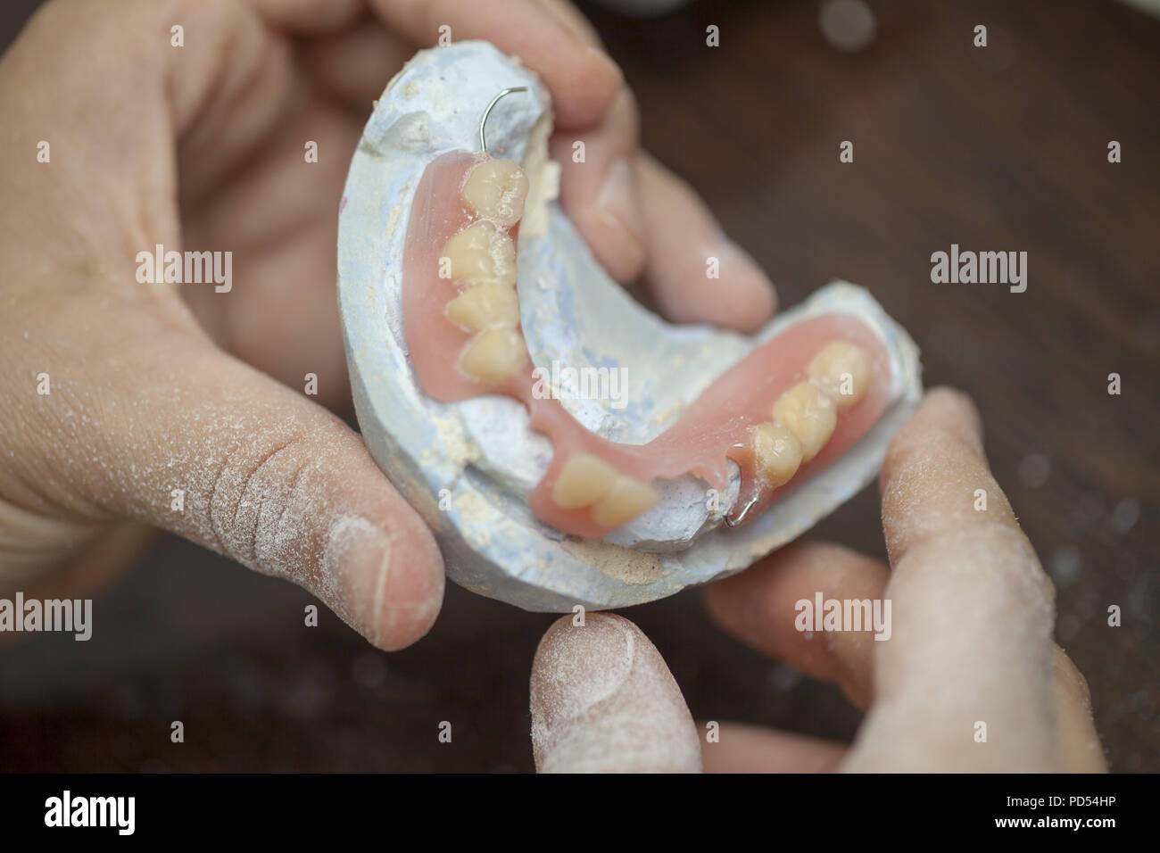 Dental technician make denture prothesis in dental laboratory, close up