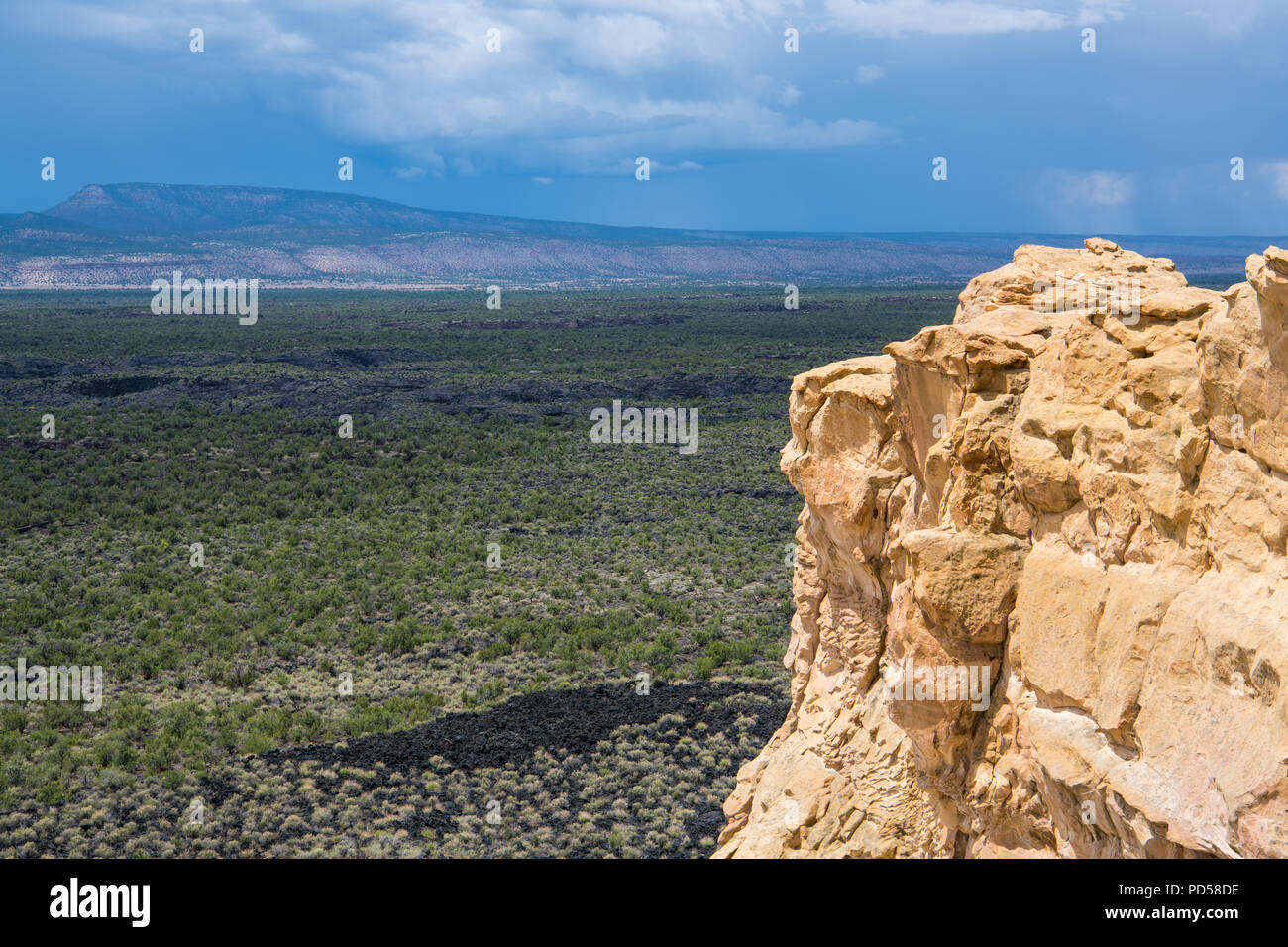 View of lava beds and cliffs under stormy skies from the Sandstone