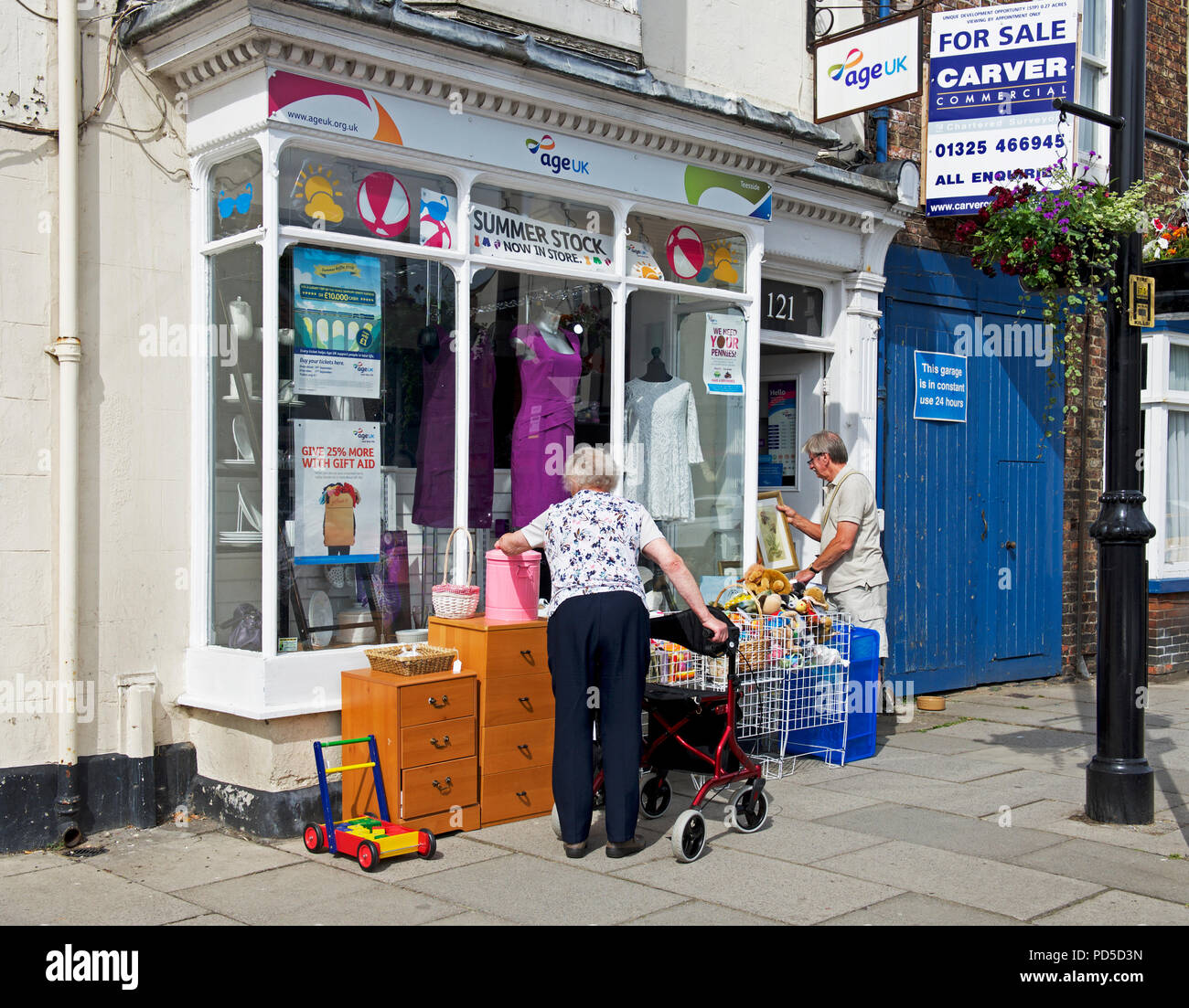 Customers outside Age Concern charity shop, England UK Stock Photo