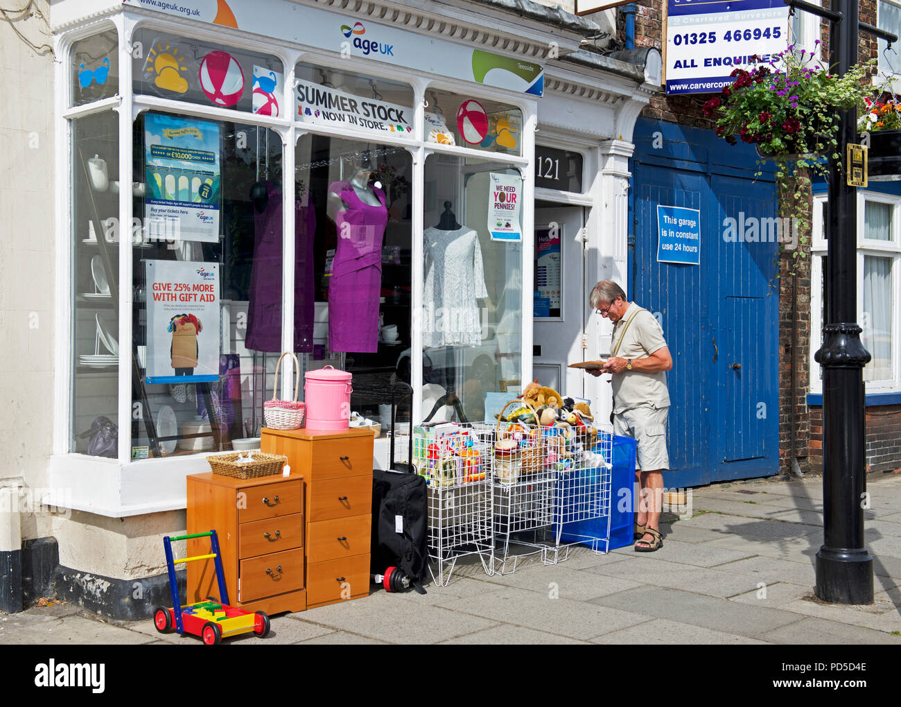 Man outside Age Concern charity shop, England UK Stock Photo