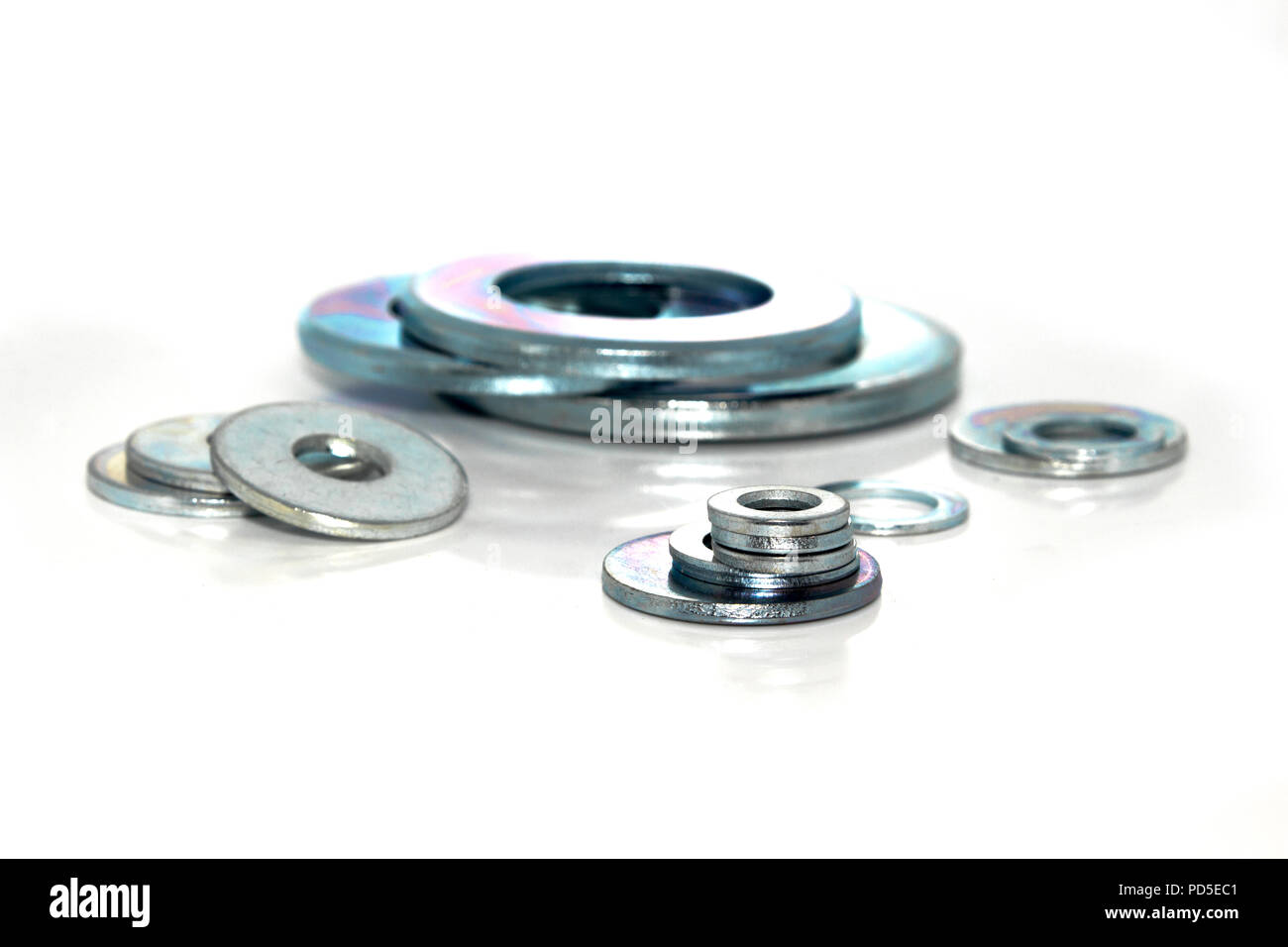 Variety of industrial galvanized steel washers on white background
