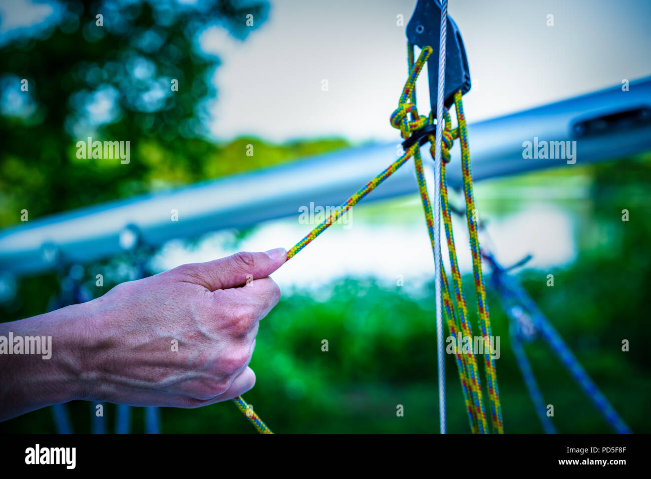 Globed hand on catamaran rope ready to sail. Hand on the sailing rops ...
