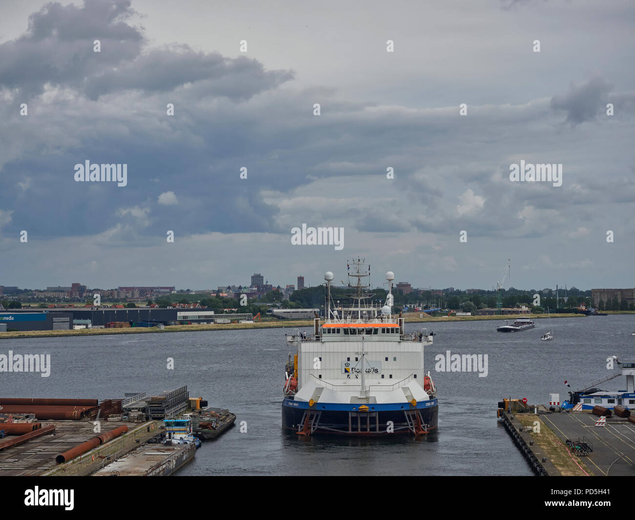 The Stemat Spirit, a Specialist Anchor Handler and Cable Laying Vessel Departing its narrow Berth in Den Haag, Amsterdam, The Netherlands. Stock Photo