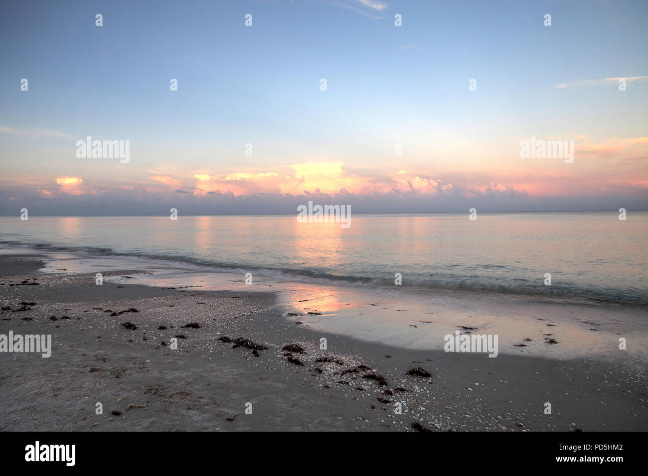 Pink sky over a calm ocean in Naples, Florida along the Gulf Coast Stock Photo