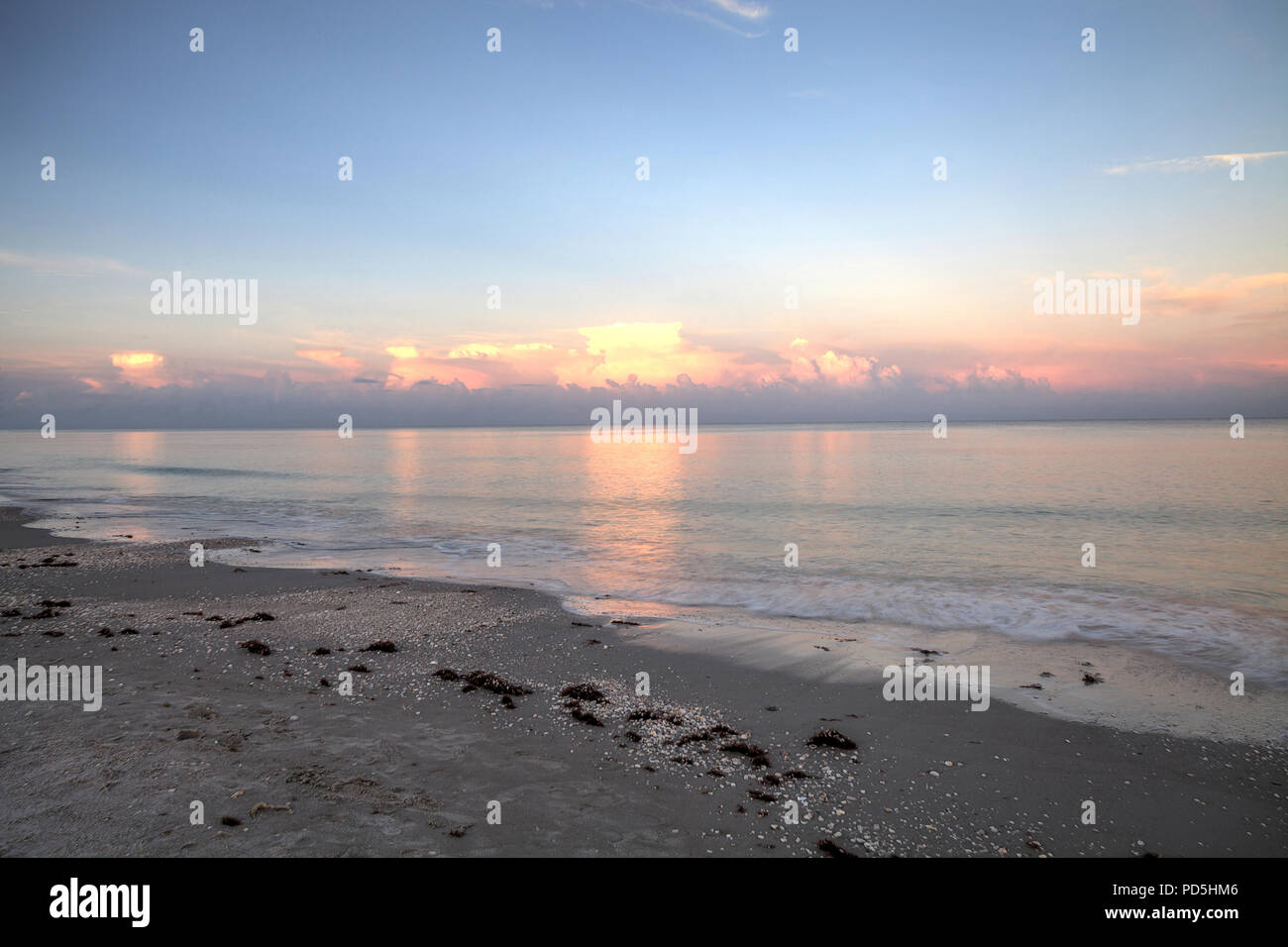 Pink sky over a calm ocean in Naples, Florida along the Gulf Coast Stock Photo