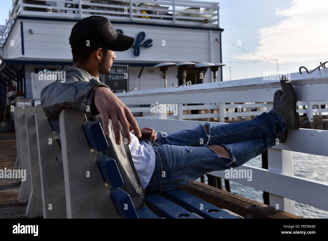 A hip, self confident young man on the Malibu Pier at sunset.  Exclusive image Stock Photo