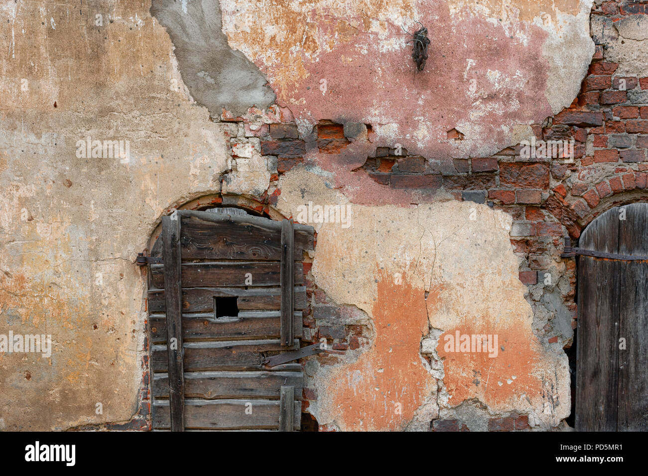 Brick destroyed wall of an ancient castle with wooden doors made of ...