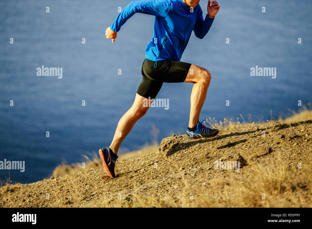 man runner dynamic running on steep slope of mountain Stock Photo