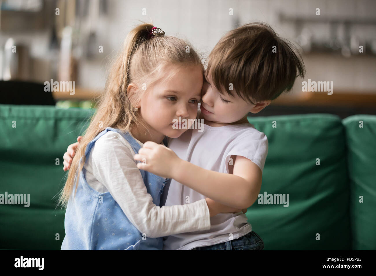 Little boy brother consoling and supporting upset girl embracing Stock Photo
