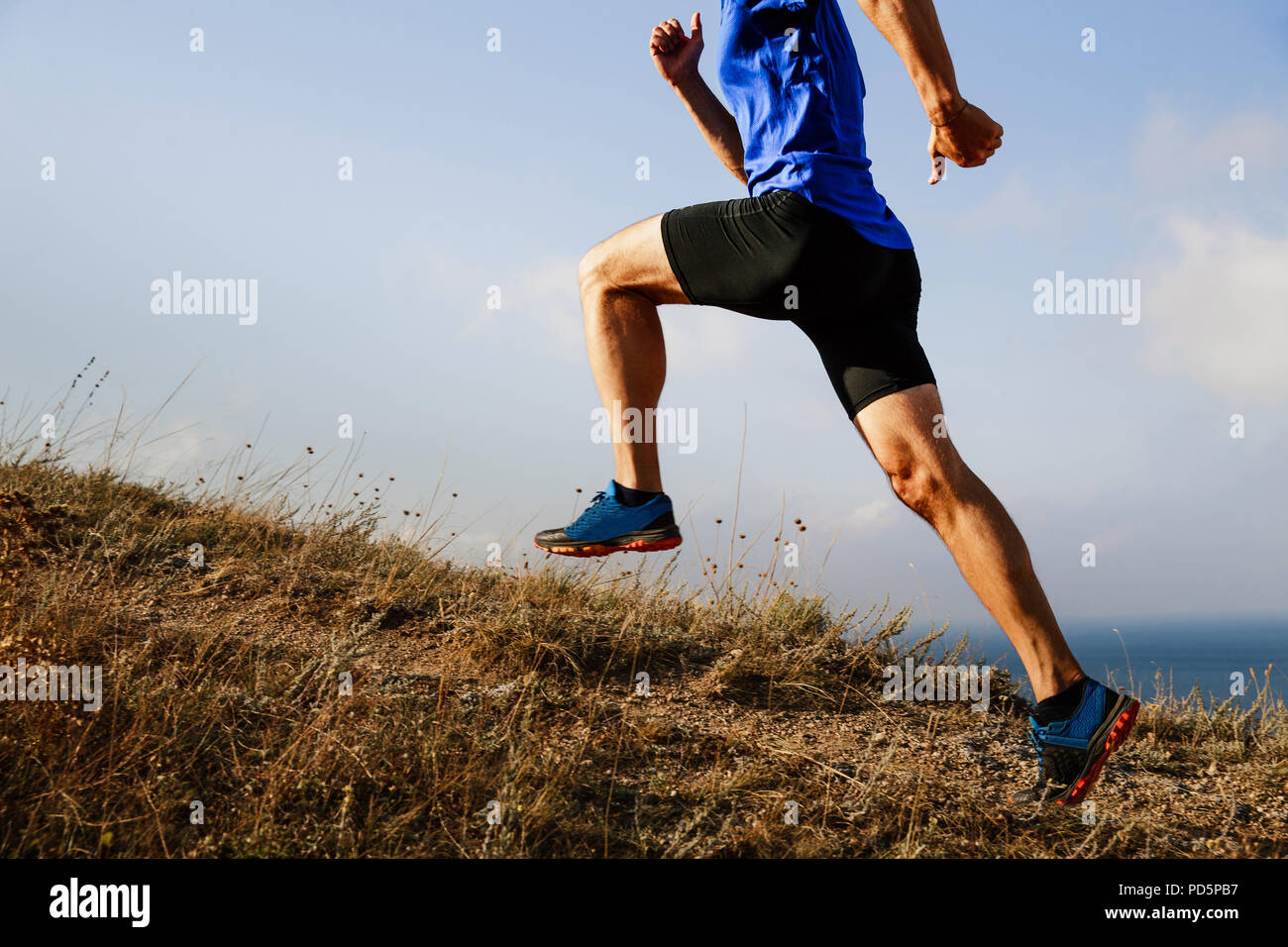 man athlete runner explosive running uphill on trail Stock Photo