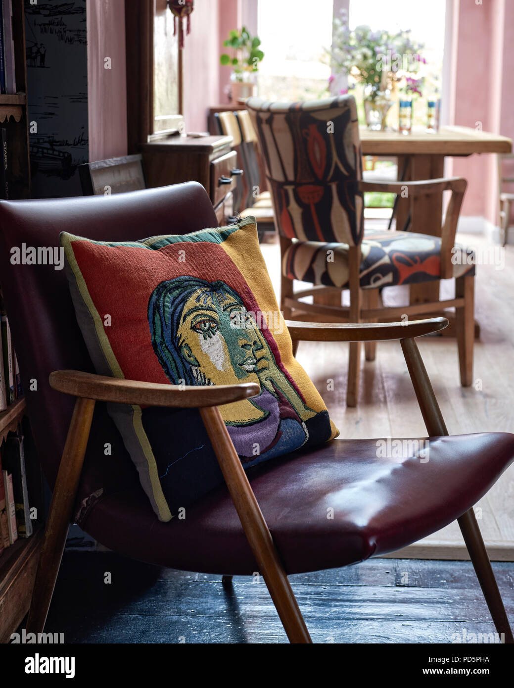 A woven jacquard cushion depicting Picasso's Dora Maar from the Conran Shop placed on a mid-century chair. Stock Photo