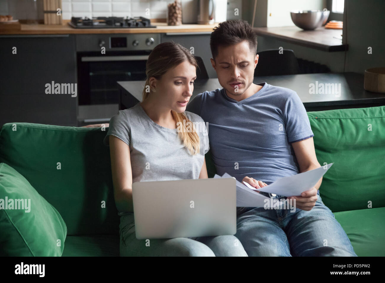 Worried couple reading documents or calculating high domestic bi Stock Photo