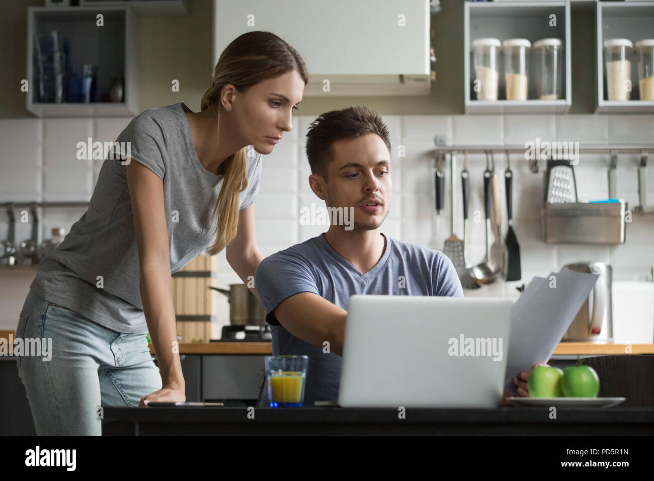 Young serious couple discussing domestic bills with papers and l Stock Photo