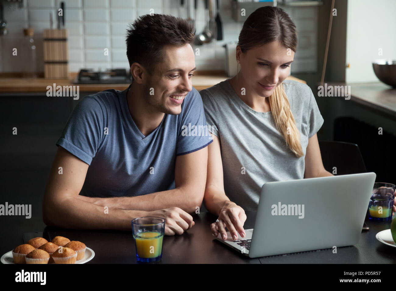 Young couple using laptop together while having breakfast at hom Stock Photo