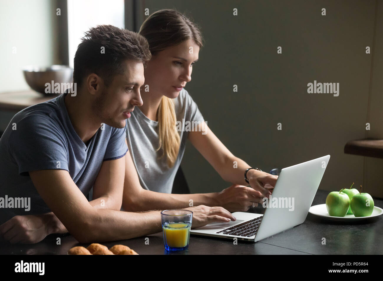 Couple using laptop for reading news or work having breakfast Stock Photo