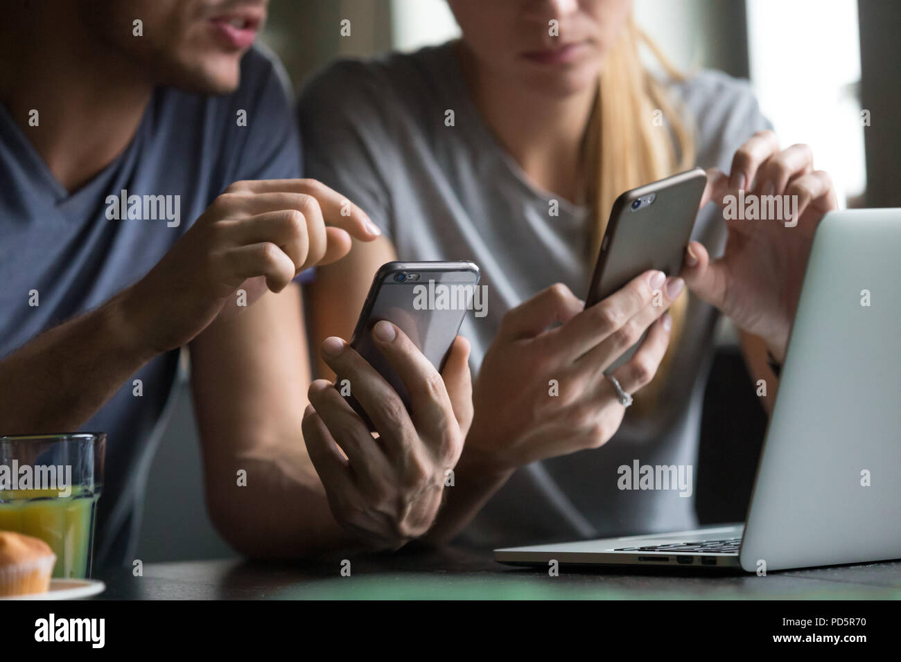 Man and woman using smartphones discussing mobile apps, close up Stock Photo