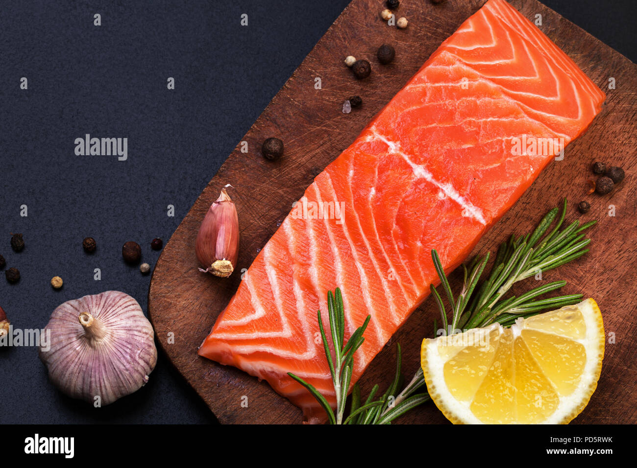 fresh raw fillet of salmon and spices on a wooden cutting board on a ...