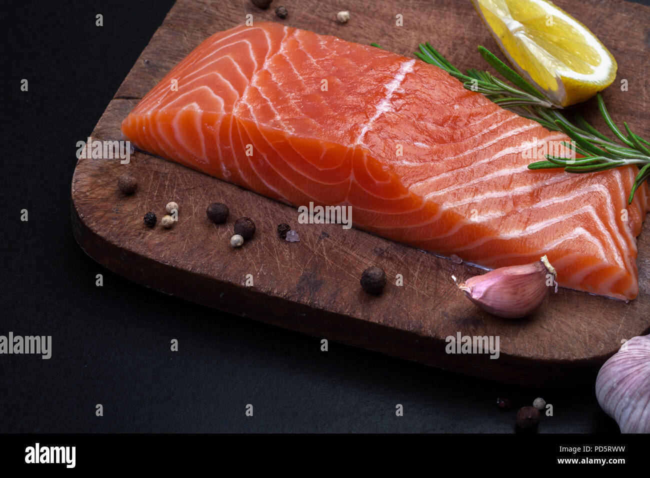 fresh raw fillet of salmon and spices on a wooden cutting board on a ...