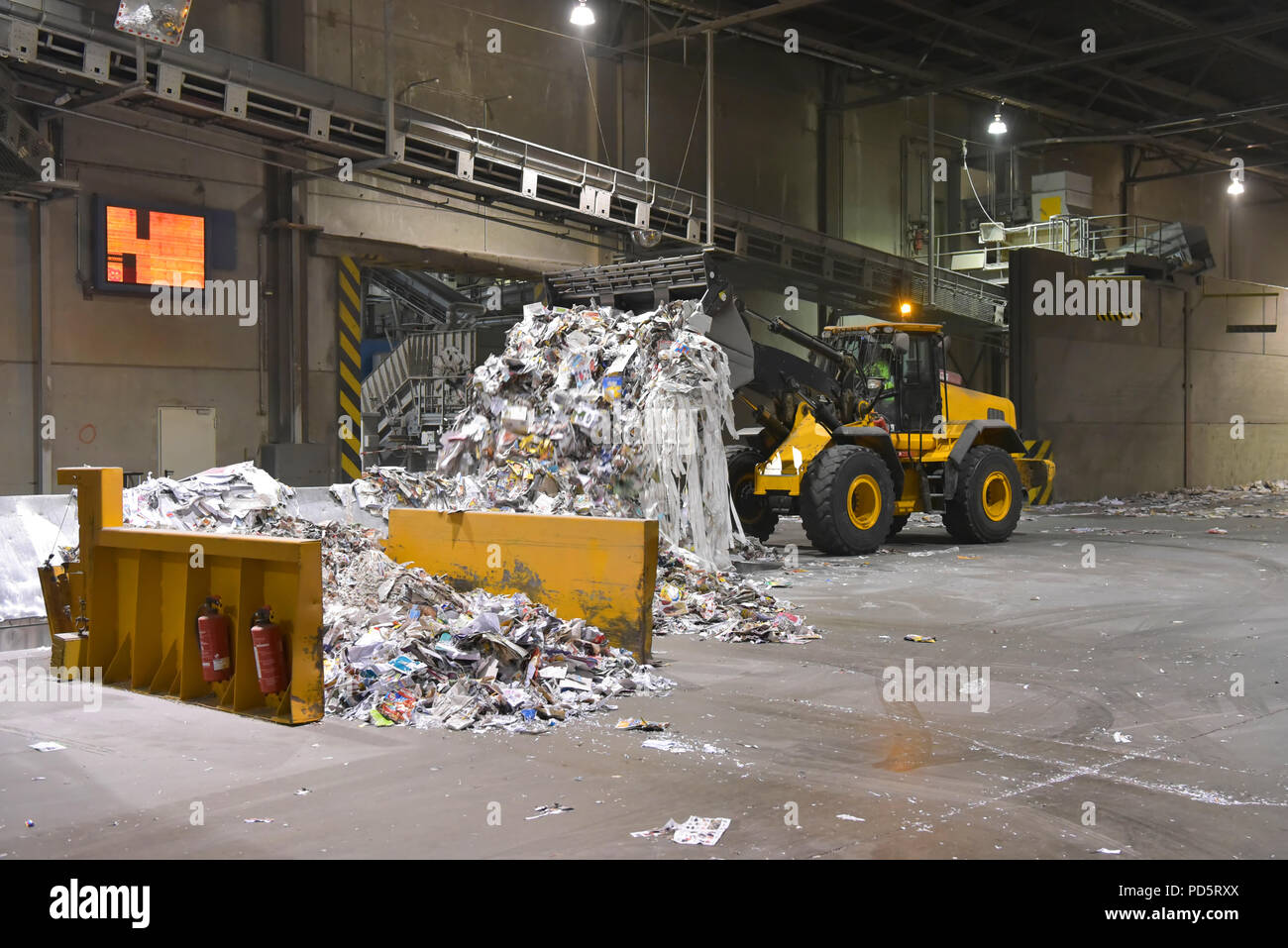 Wheel loader transports waste paper for recycling in a mill - paper production in a mill Stock Photo