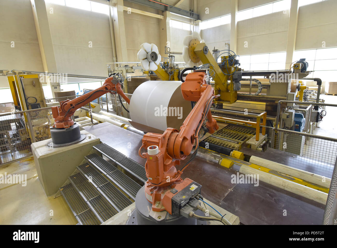 Industrial robot in a paper mill - automation in a modern plant - recycling of waste paper Stock Photo